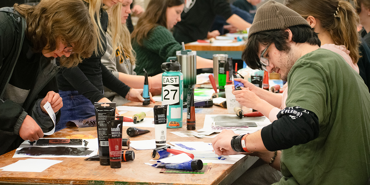 Students sitting at a table working on an art project