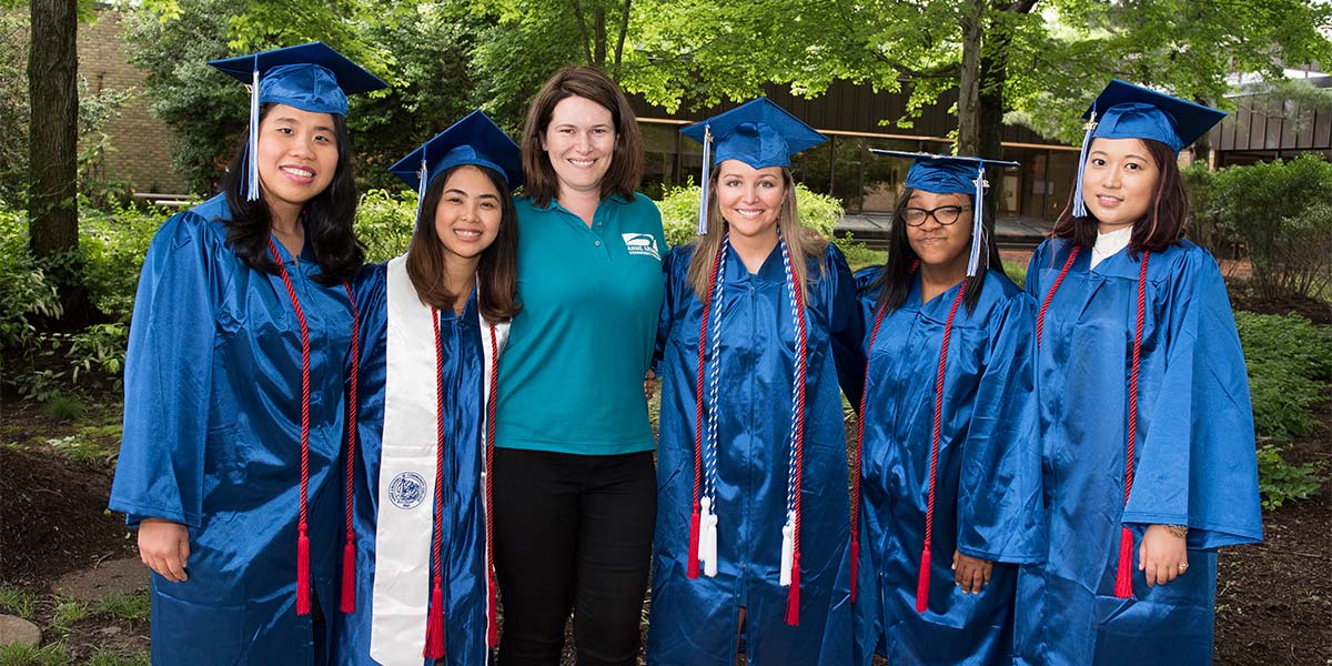 Campus ambassadors pose in cap and gowns.