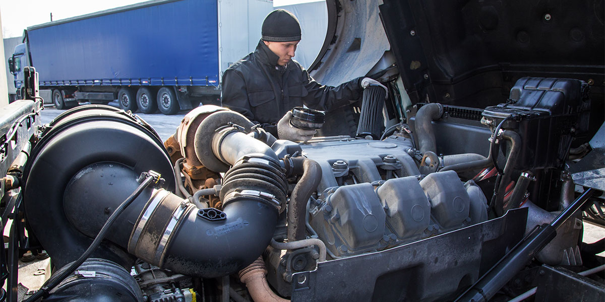 Student surveying large diesel engine.