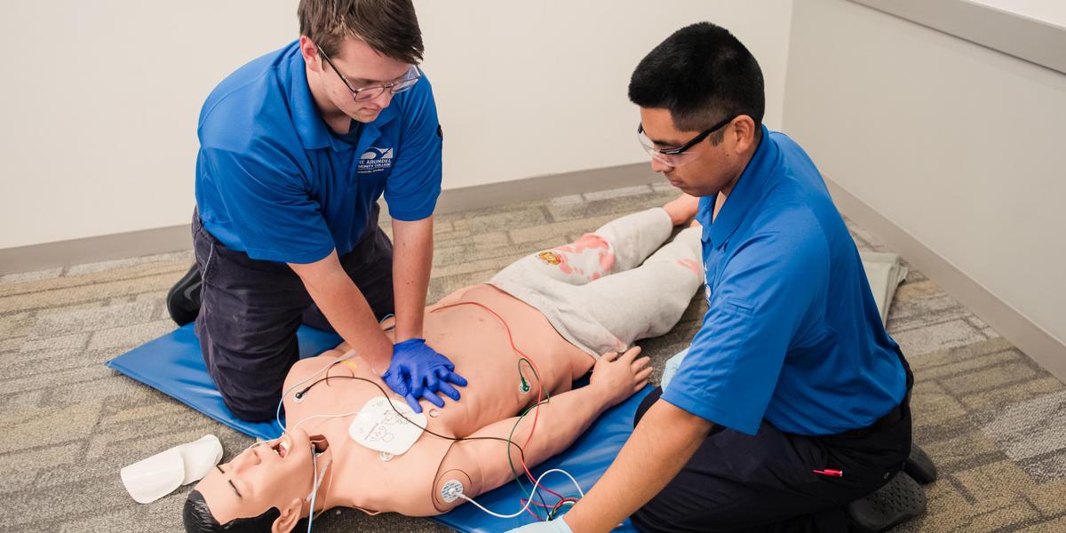 EMT students with mannekin doing CPR.