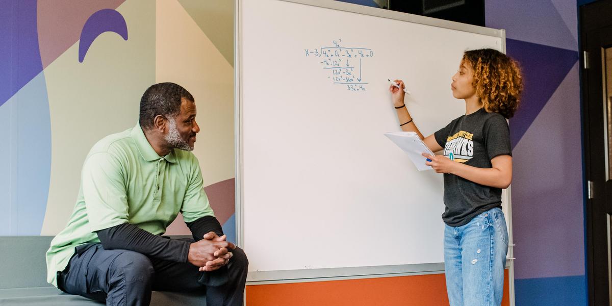 Student doing math on white board