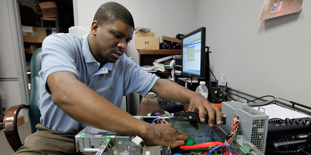 Student works on the inside of a computer.