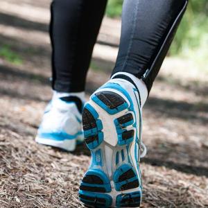 Lower half of individual walking on a trail.