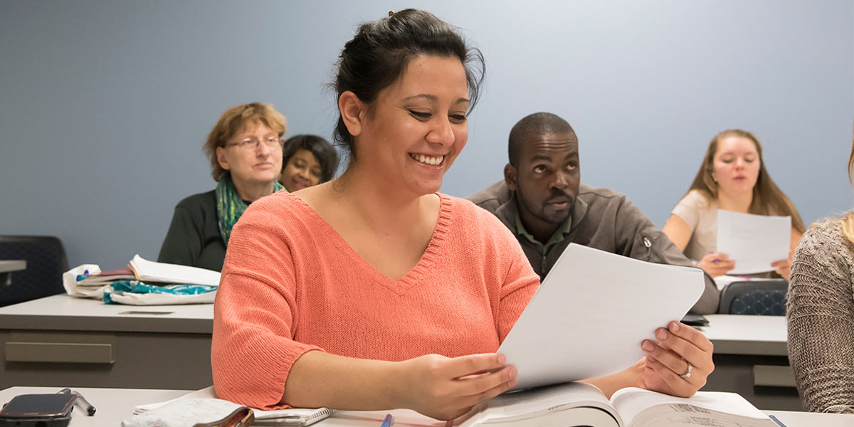 AACC student reviewing a handout in her classroom.