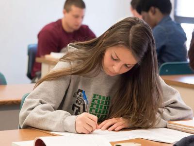 Female student working at her classroom desk.