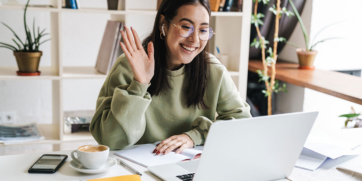 Student waves at her computer.