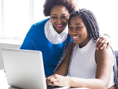 Mom and student look at computer.