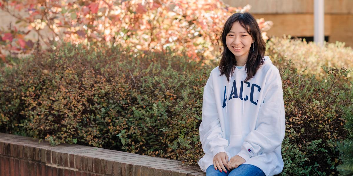 Student smiling for camera while outside.