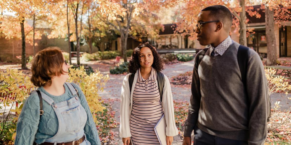 Students talking to one another outside during the fall season.